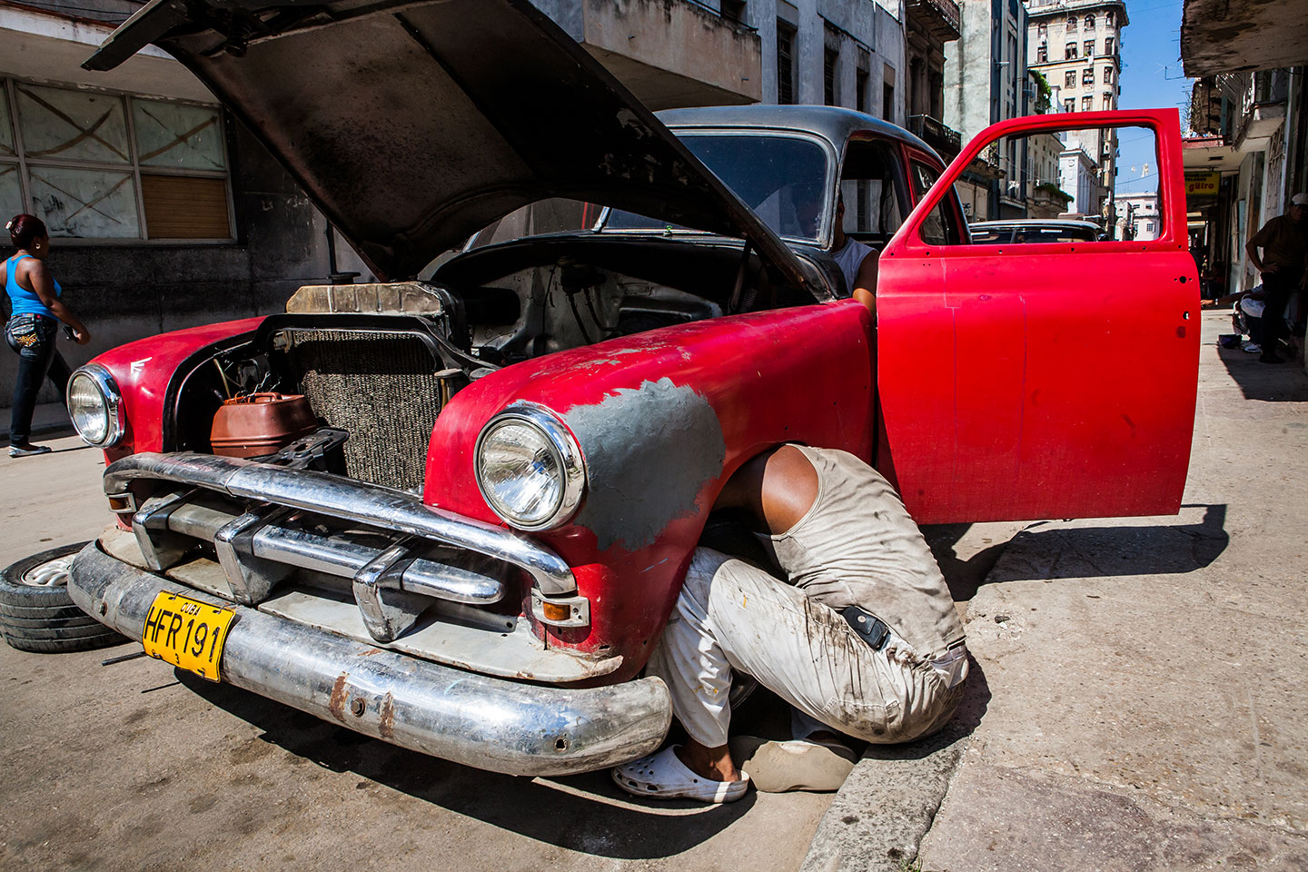 Mechanic working on vintage car in Havana, Cuba