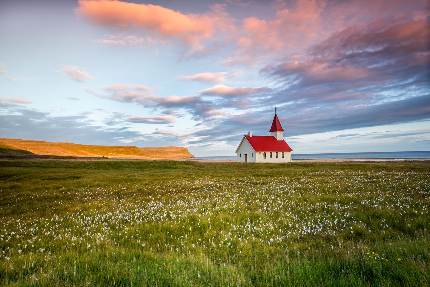 Red roofed church on a beach in Breidavik, Iceland