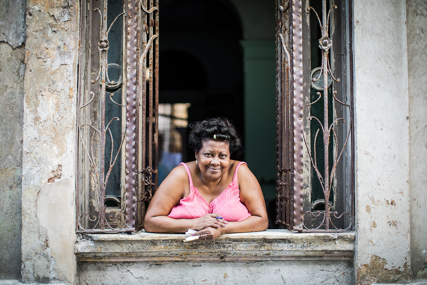 Woman hanging out of a window of an old building in Trinidad, Cuba