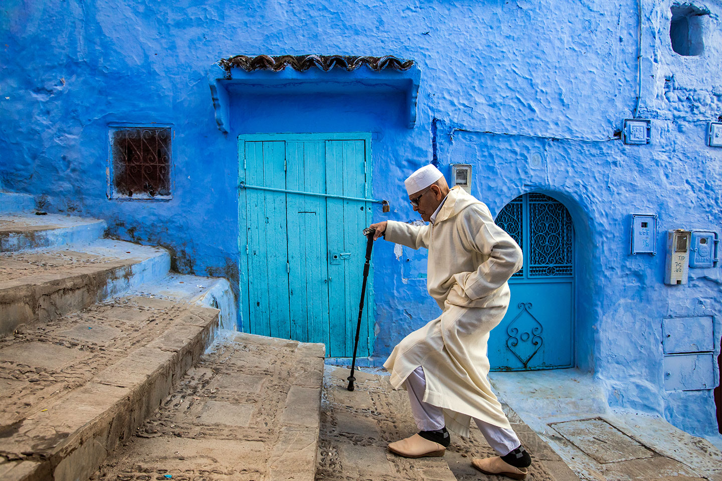 Man on steps in the blue town of Chefchaouen in Morocco
