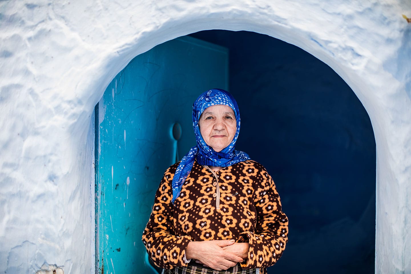 Women at her doorstep in the blue town of Chefchaouen, Morocco